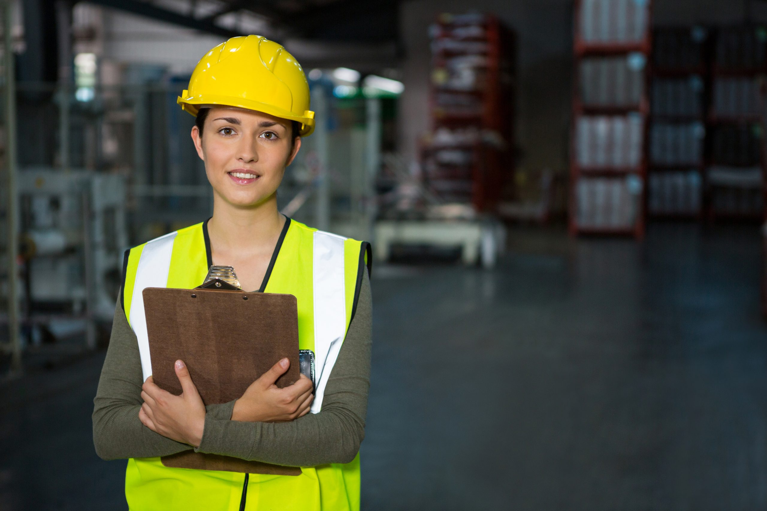 Portrait of confident female worker holding clipboard in warehouse